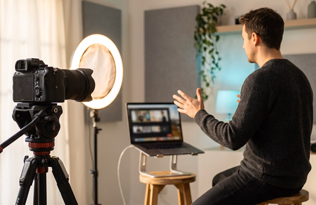 A professional presenting a live webinar to a ring light and camera in a bright home studio