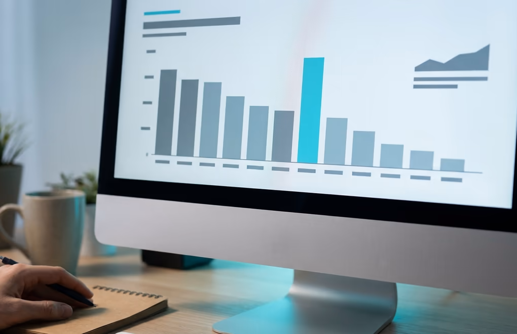 A monitor showing a clean bar chart comparing lead cost across marketing channels, no labels visible