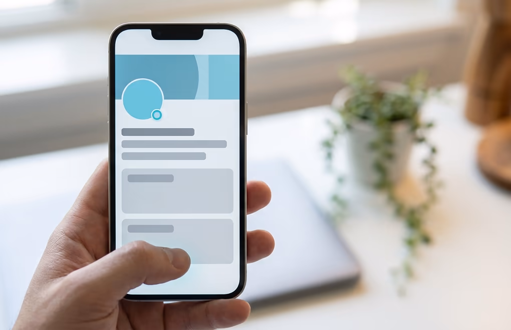 A LinkedIn profile on a phone rewritten to attract clients with a clear headline
