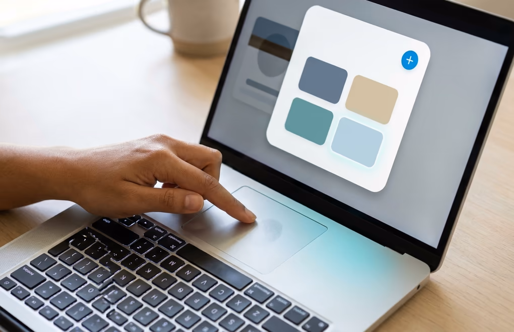 Hands adding a new item to a featured row from the add profile section menu on a laptop