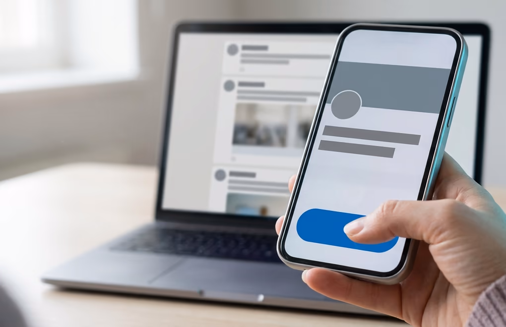 A phone showing a LinkedIn profile and connection request beside a laptop feed of prospect posts